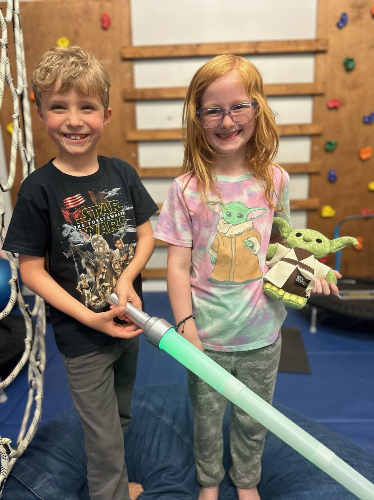 Children smiling with Star Wars toys.