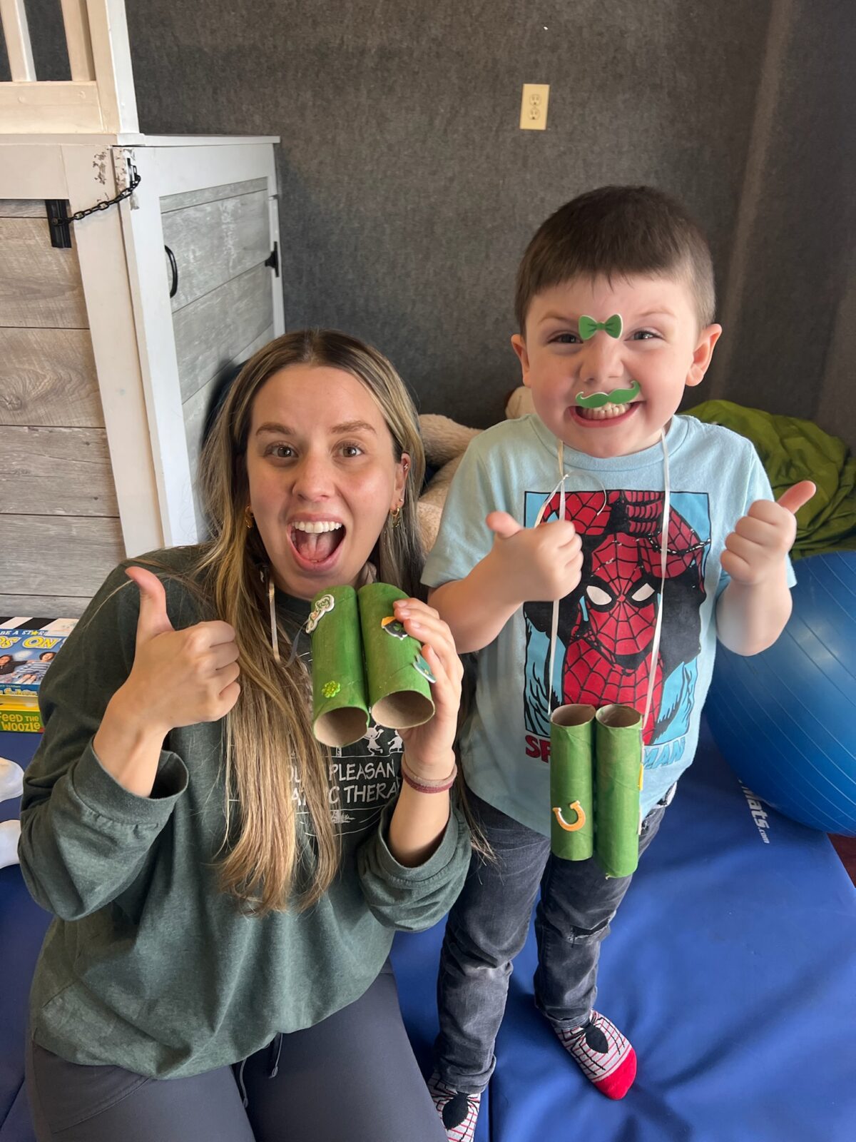 Woman and child smiling, giving thumbs up.