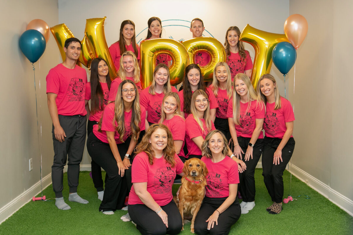 Group photo with balloons and a dog.