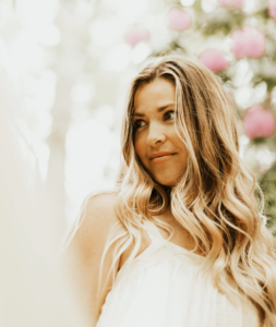 Smiling woman with long hair outdoors.