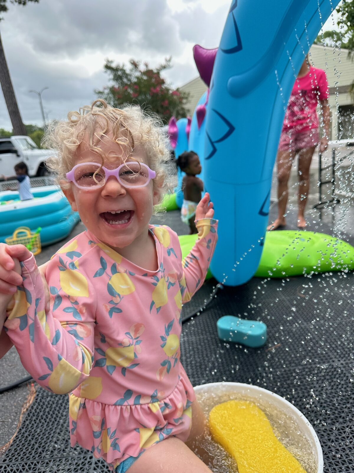 Smiling child playing at outdoor splash park.