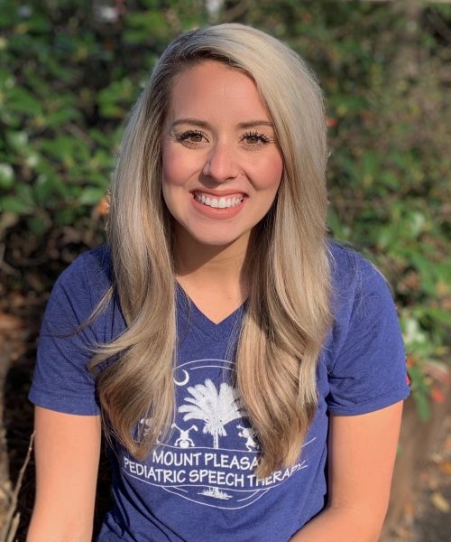 Smiling woman outdoors in blue shirt.