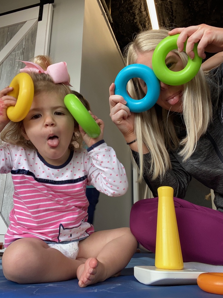 Child and adult playing with colorful rings.