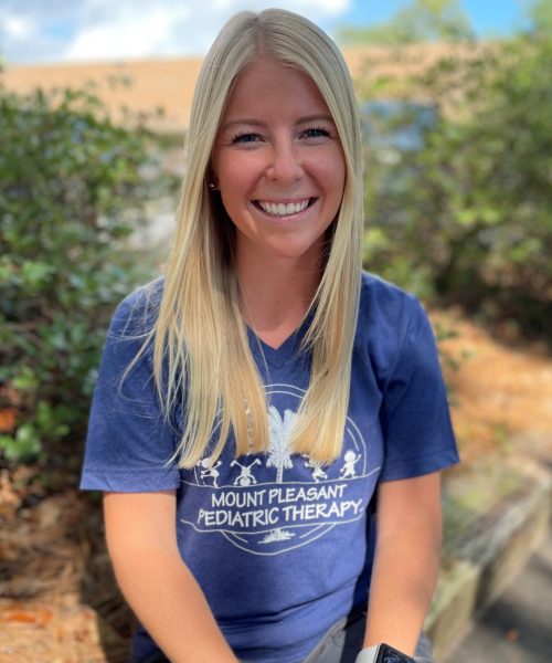 Smiling woman outdoors in a blue shirt.