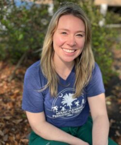 Smiling woman outdoors in blue shirt.