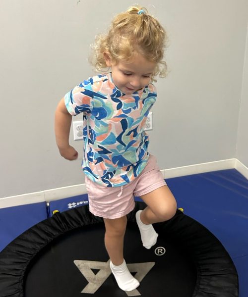 Child jumping on a small indoor trampoline.