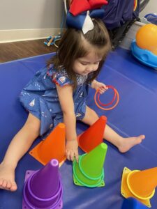 Child playing with colorful cones and rings.
