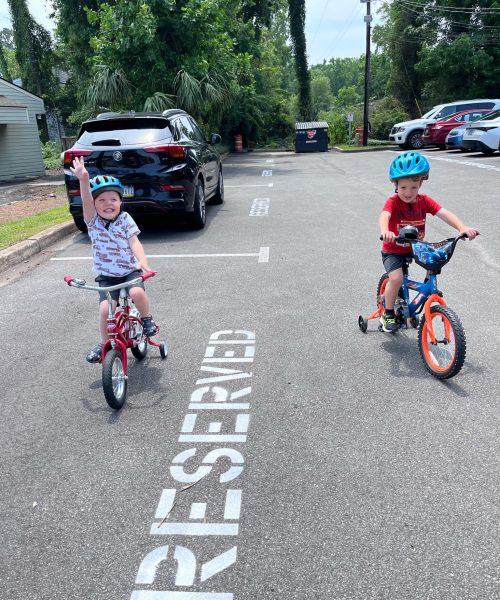 Children riding bikes in a parking lot.