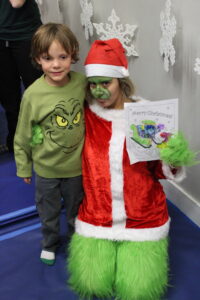 Child with Grinch-themed holiday character costume.