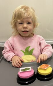 Young child with buttons and pictures.