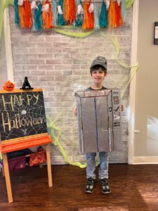 Child in elevator costume, Halloween decorations nearby.