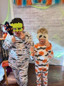 Kids in Halloween pajamas and masks.